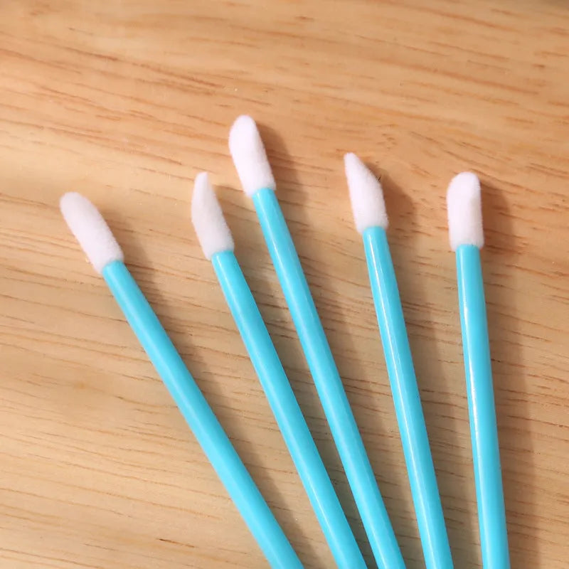 Pack of disposable lip brushes with flocked heads and coloured handles, shown in quantities from 200 to 500 pieces.