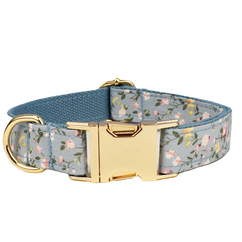 Blue floral pattern dog collar accessories set with adjustable collar, matching leash, bow, vest, and poop bag