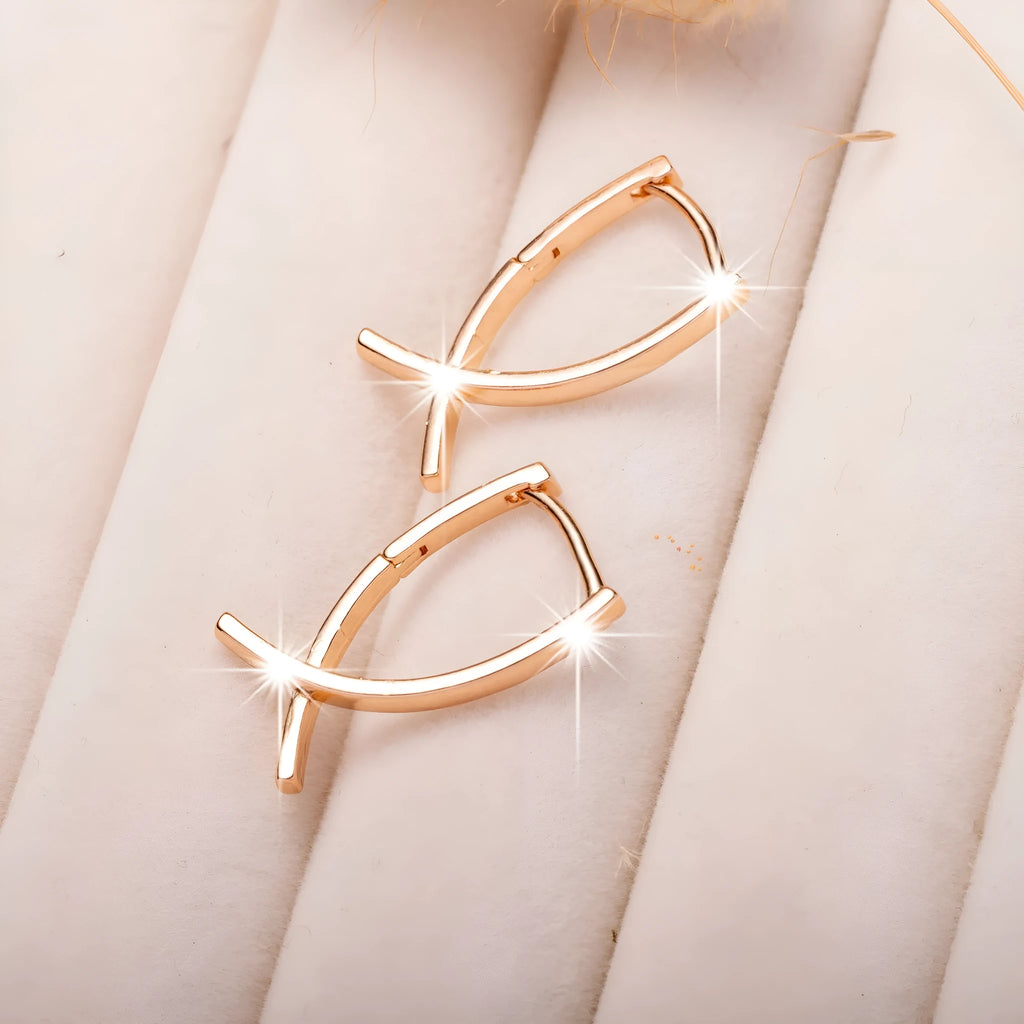 Rose gold cross shaped earrings with copper construction and light luxury aesthetic