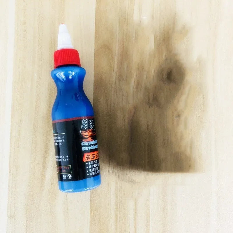Small blue car scratch repair agent bottle with integrated wiping tool for automotive paintwork