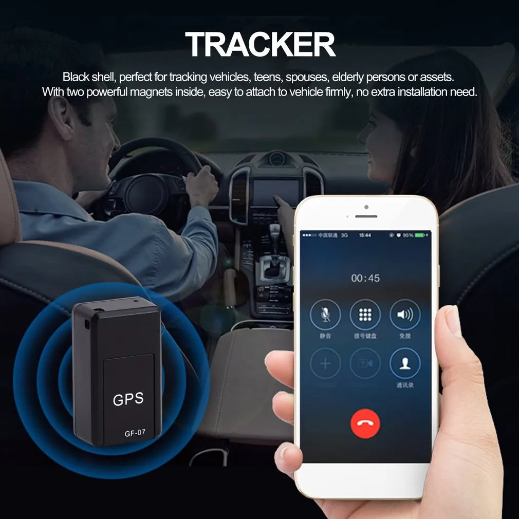 Black mini magnetic GPS tracker next to USB charging cable on a dark surface.