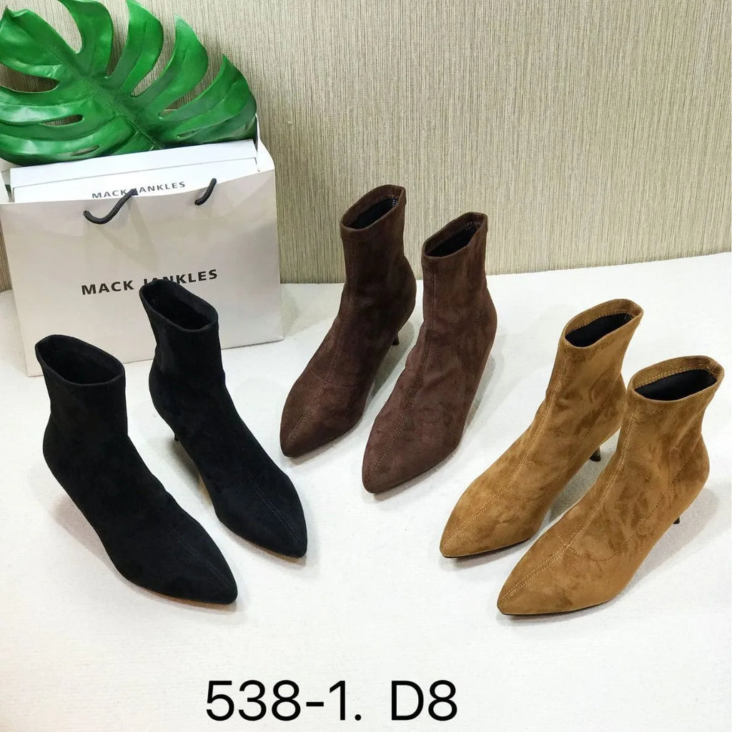 Women's black pointed toe ankle boots with stiletto heel on a plain background