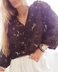 Black lace cardigan shirt with 3D floral embroidery and a V-neck, shown on a hanger.