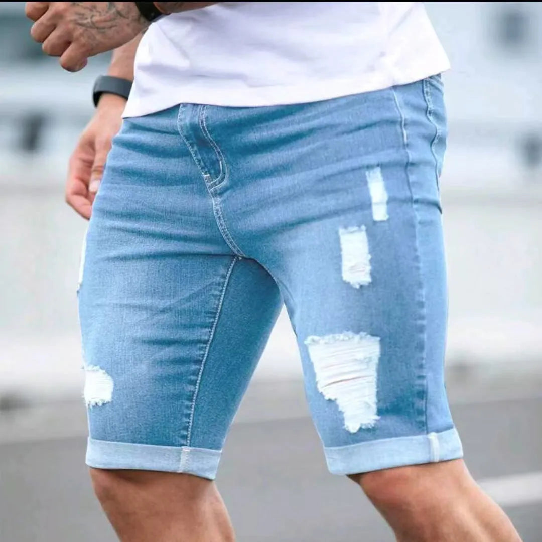 Men's sky blue denim shorts with distressed multi-hole design, low waist, and zip fly opening