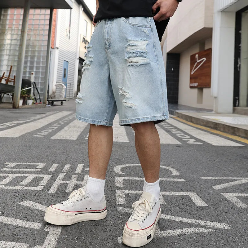 Light blue loose-fit ripped denim shorts with distressed details on a straight-leg silhouette.
