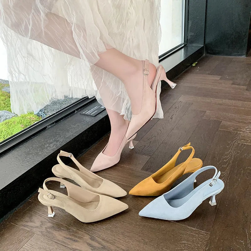 A pair of women's apricot suede stiletto heels with a pointed toe and thin high heel.