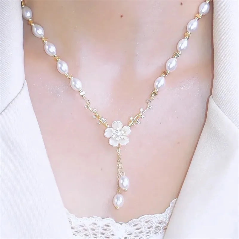 Alloy fashion necklace with pearl flower and rose decoration on a chain.