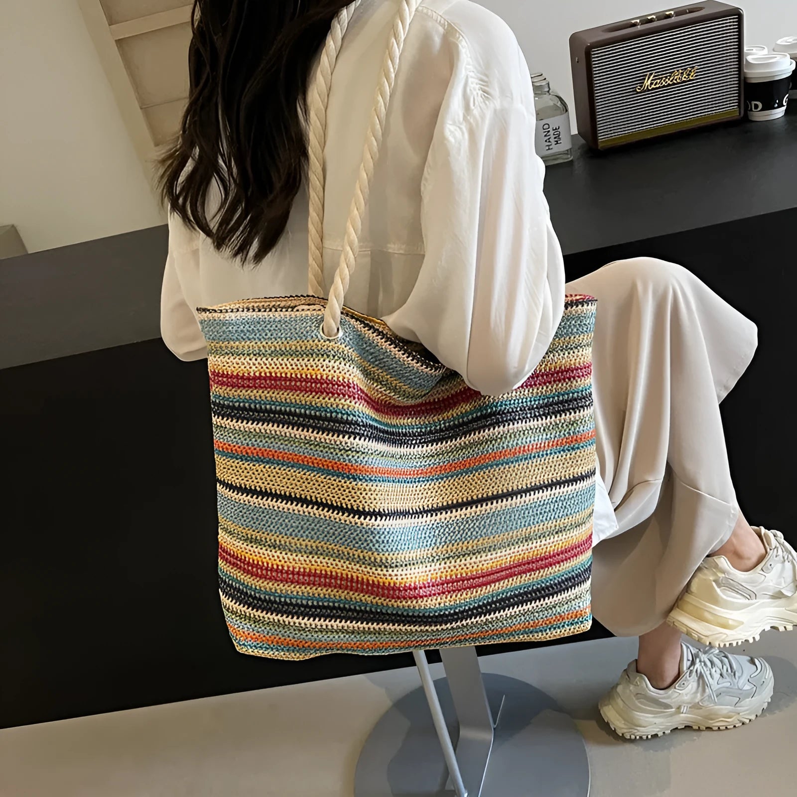 Blue straw woven nylon shoulder bag with a large capacity and polyester lining.