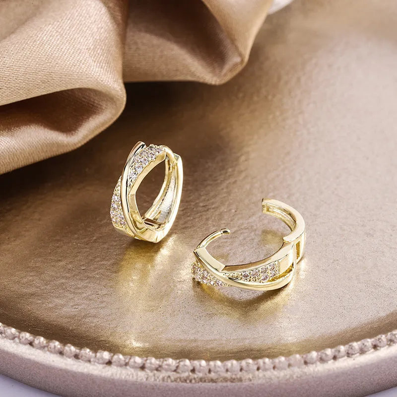 A pair of geometric stud earrings with zircon detail and 14K yellow gold plating on a copper base.