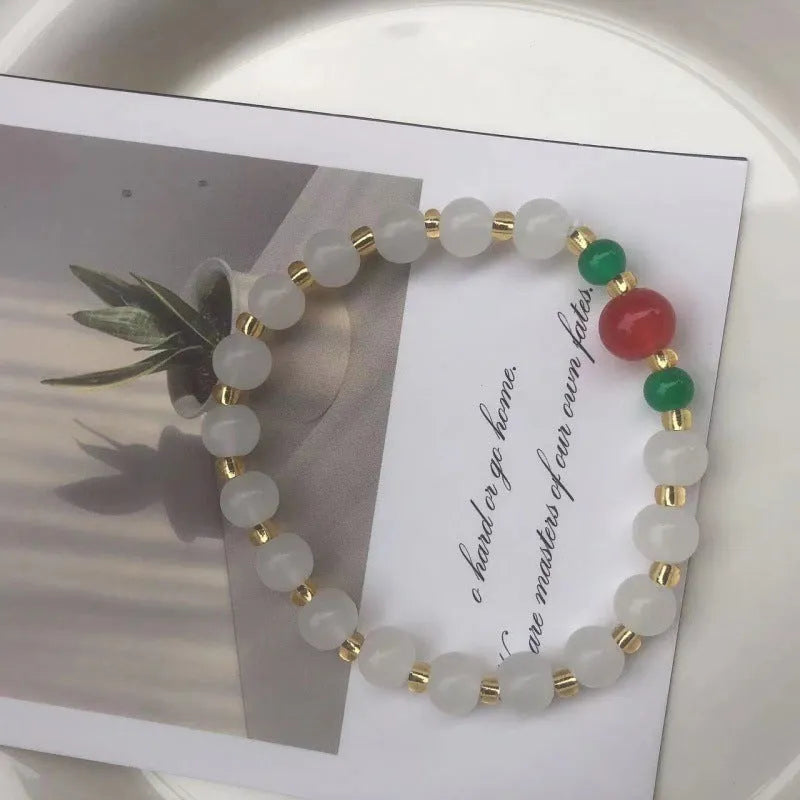 Chinese style handmade glass bead bracelet with bamboo joint elements on a white background.