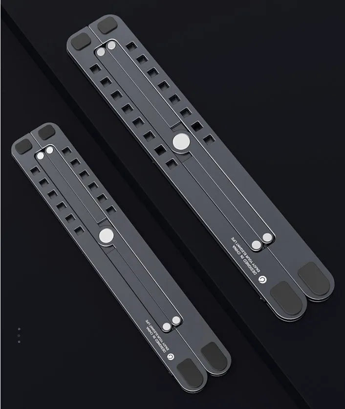Aluminium laptop stand in silver, folded flat next to an open laptop showing its adjustable height mechanism.