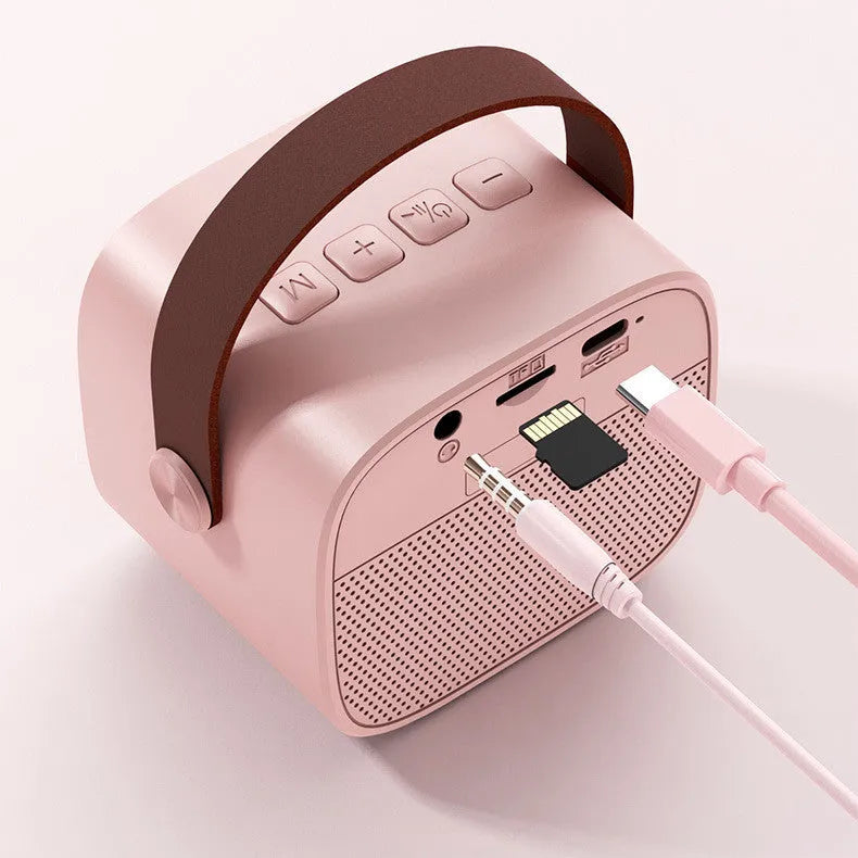 Compact white wireless Bluetooth speaker with USB port shown on a table.
