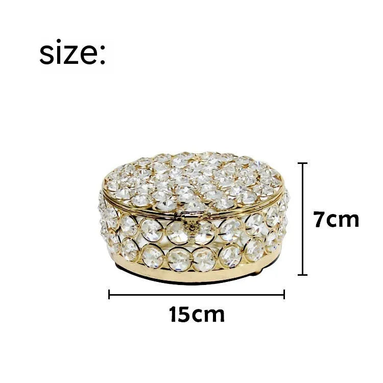 French gold metal jewellery box with a transparent crystal glass lid on a table.