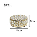 French gold metal jewellery box with a transparent crystal glass lid on a table.