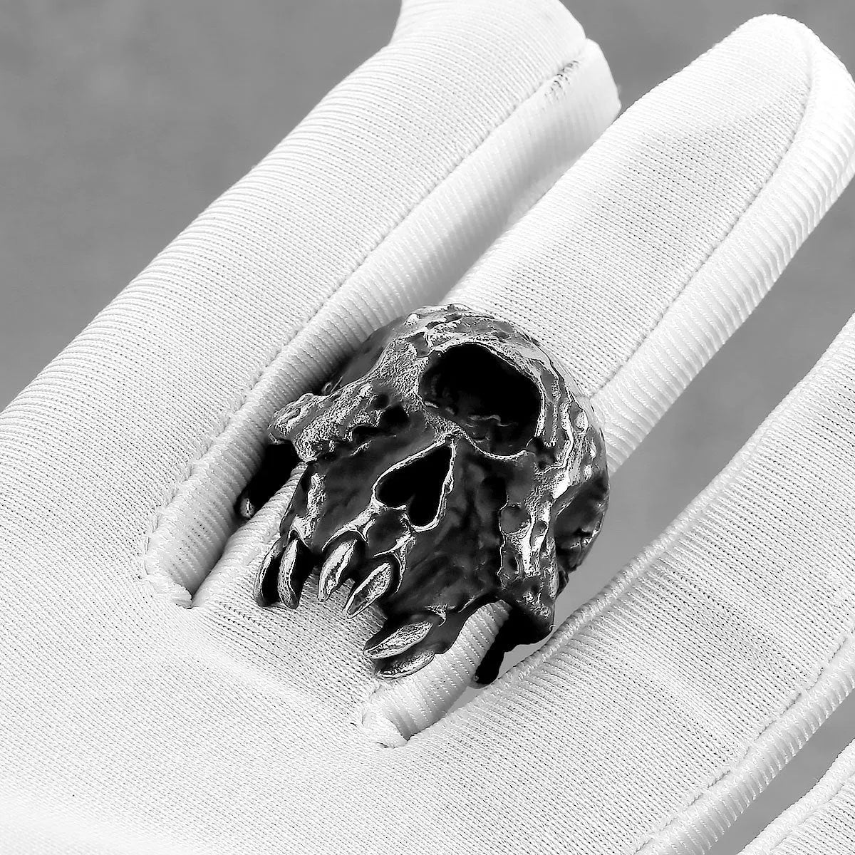 Silver-toned alloy skull ring with a detailed one-eyed design on a black background.