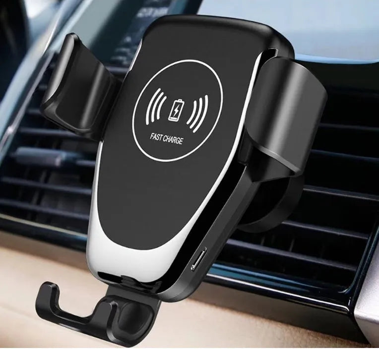 Black wireless car charger mounted on a car air vent, holding an iPhone.