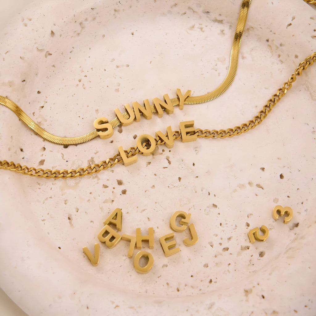 Gold and silver titanium steel personalised necklace showing number and letter pendant options on 40.5cm chain