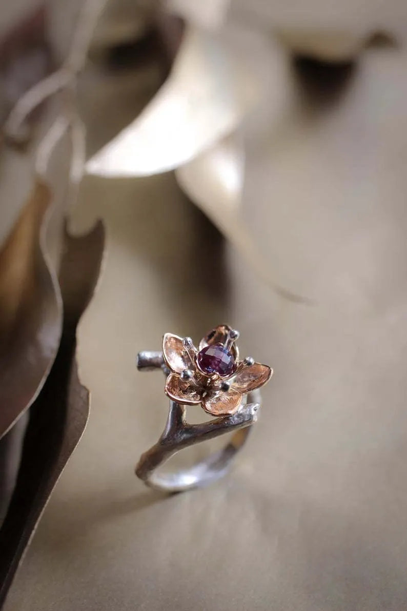 Two-tone silver alloy women's ring with floral geometric design on a flat surface