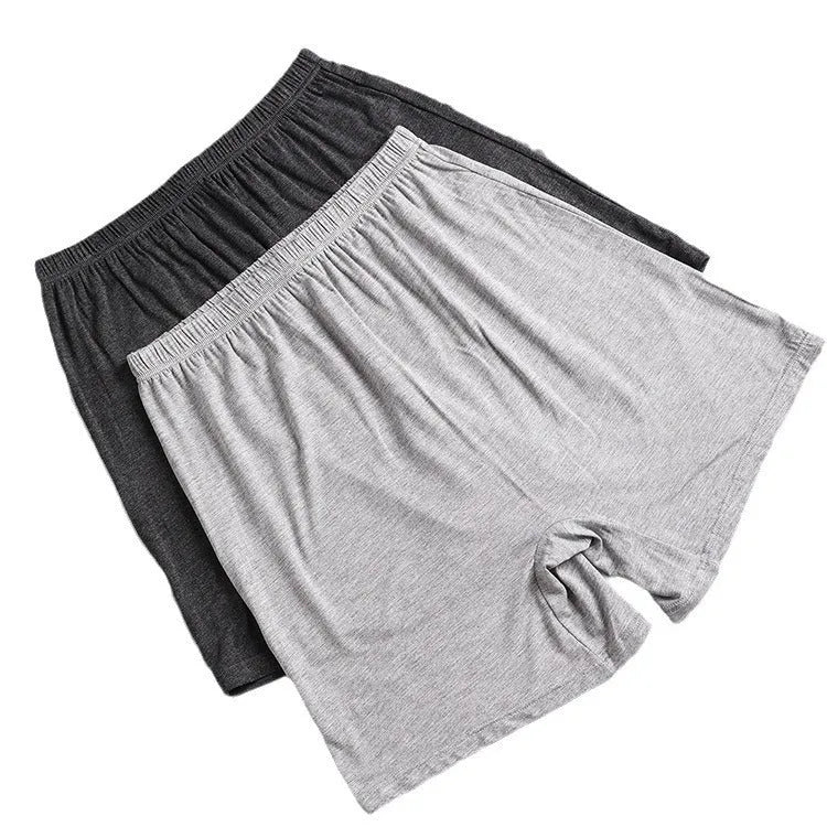 Man holding a pair of solid colour high-waist modal boxer shorts in dark grey.