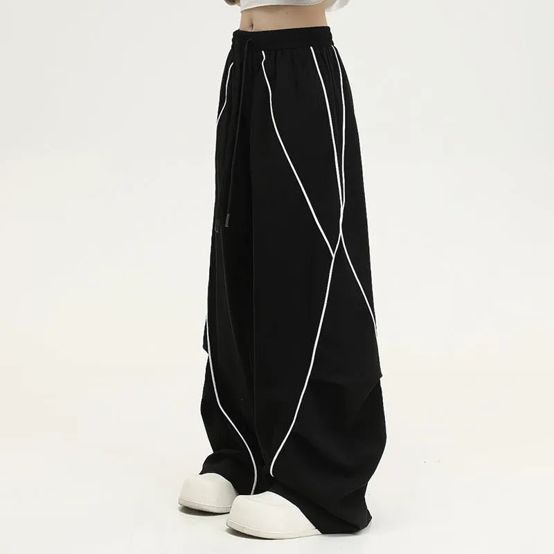 Black pleated wide-leg trousers with stripe pattern showing loose fit and mid waist design