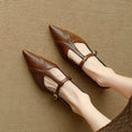 Brown women's pointed toe low-cut flat shoes with a mid heel on a neutral background.