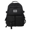 Black and white nylon student backpack with laptop compartment, showing three-dimensional pocket.