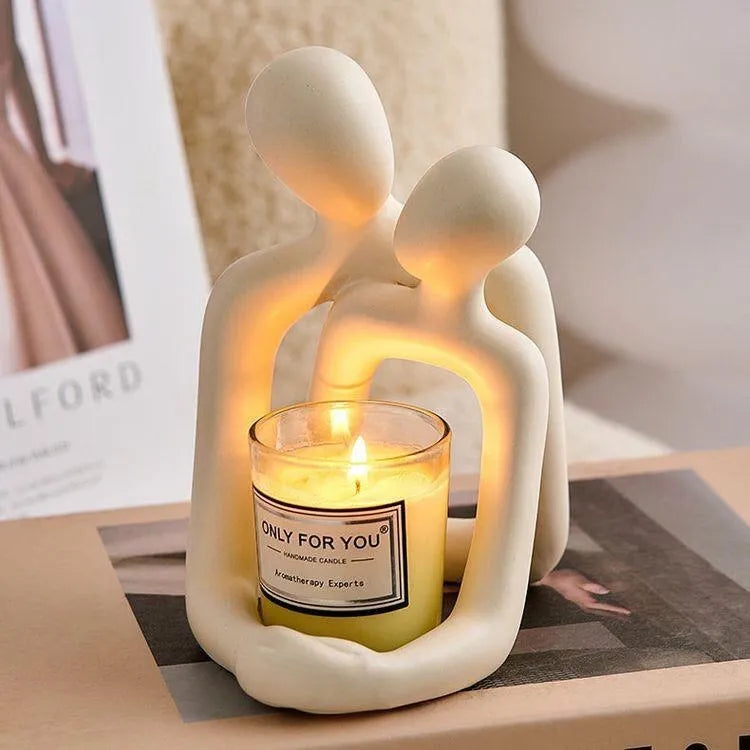Modern couple resin statue in milky white or gold on a wooden surface.