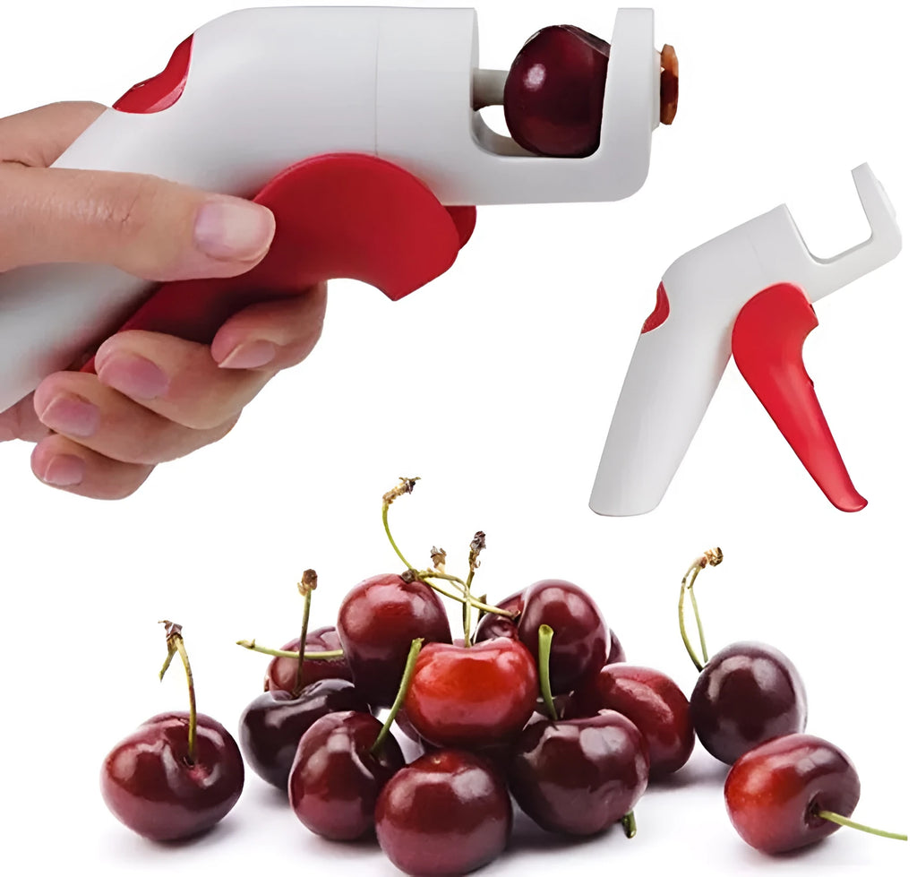 Cherry stoner tool with stainless steel pitting head and white plastic handle on a wooden surface.