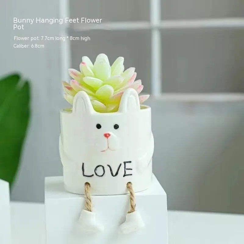 Ceramic cartoon-style hanging foot flowerpot for succulent plants on a desktop.