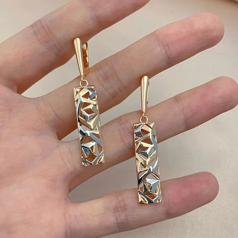 A pair of women's rectangular hollow stud earrings with a two-tone metal finish.