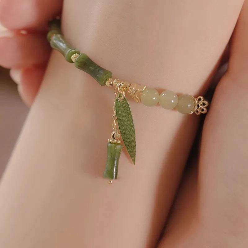 Chinese style handmade glass bead bracelet with bamboo joint elements on a white background.
