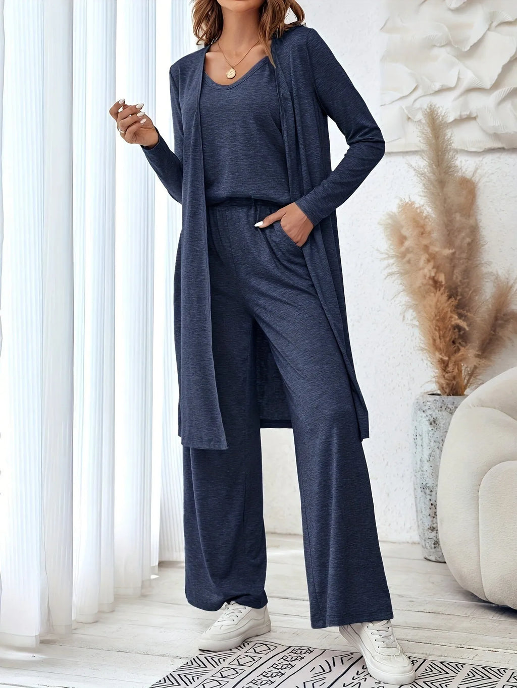 Blue women's three-piece casual suit set with sling top, long cardigan, and trousers on a hanger.