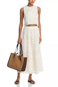 White women's sleeveless top and long skirt suit with embroidery detail on a mannequin.