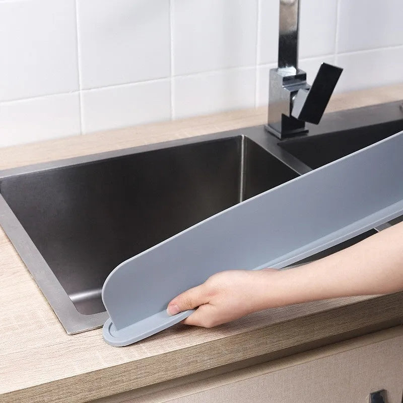 A thick grey silicone water blocking plate for a kitchen sink, shown next to a sink edge.