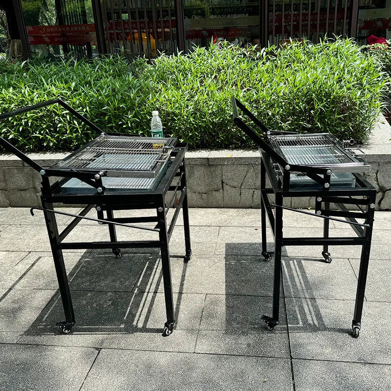 Large portable foldable charcoal barbecue grill stove shown in a garden setting