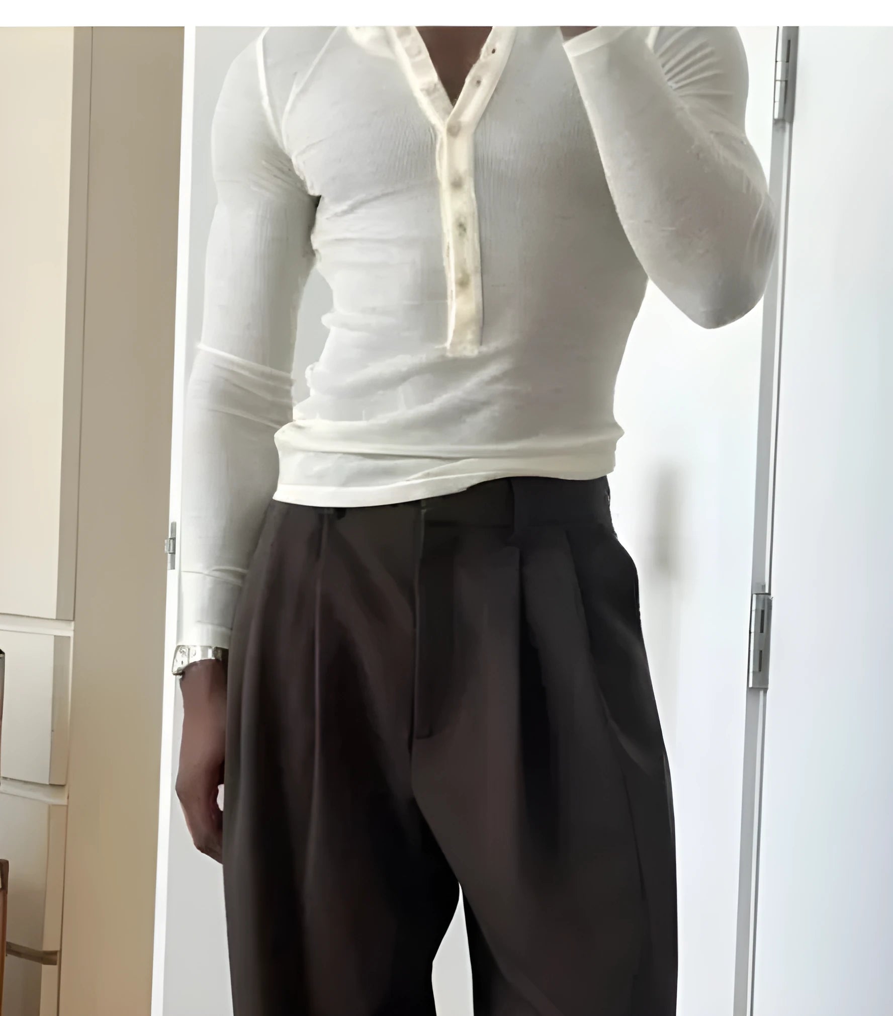 Men's cream coloured ribbed long sleeve henley top on a hanger, showing three-button placket.