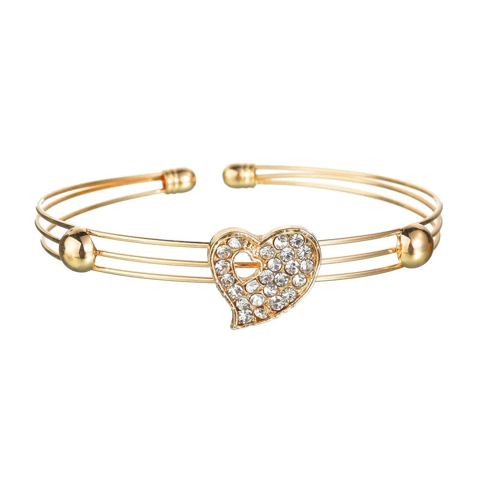 Gold electroplated women's jewellery set with love bell patterns including earrings, pendant and adjustable bracelet