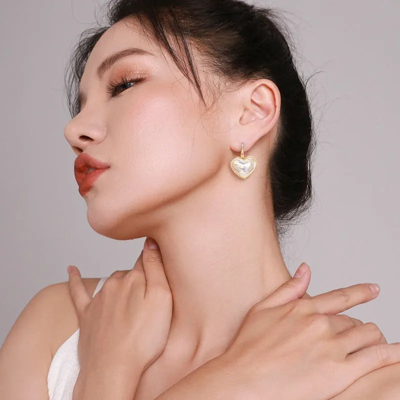 Gold coloured women's clip-on earring made from alloy with metal design details.