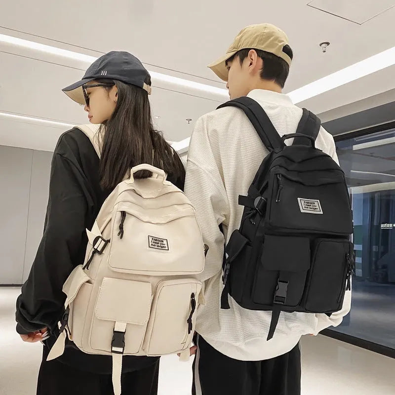 Black and white nylon student backpack with laptop compartment, showing three-dimensional pocket.