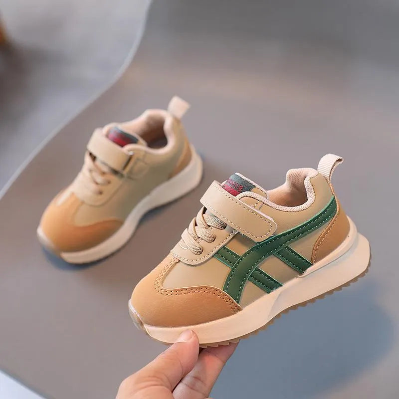 Children's white synthetic leather sneaker with a single Velcro strap and rubber sole.