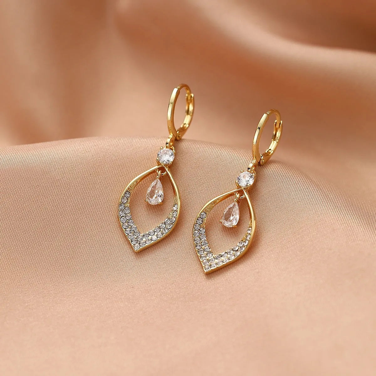 Copper tear-drop shaped earrings with zircon detailing and tassel finish, showing gold and silver electroplated buckle options