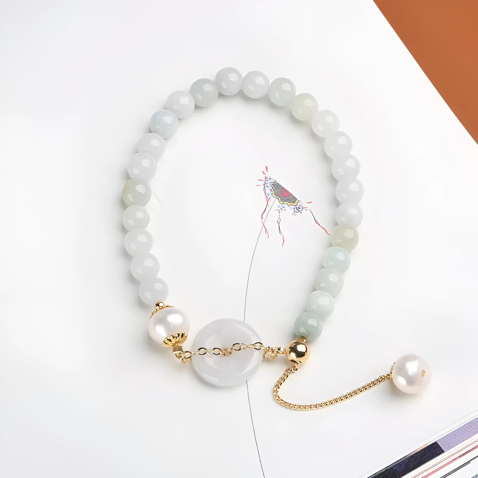 Jade green pearl bracelet with geometric pendant and peace buckle clasp on wrist
