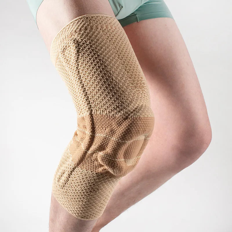 Black and blue adult sports knee pad made from nylon and spandex, shown on a knee.