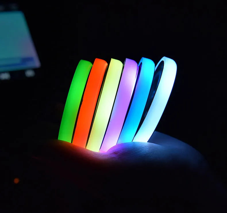 Colourful LED light-up coaster for car cup holder showing multiple light colours on a dark surface.