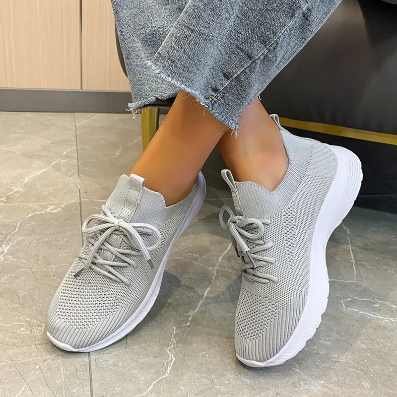 Women's low-top running shoes in creamy white with Flyknit mesh upper and a detailed English muffin heel.