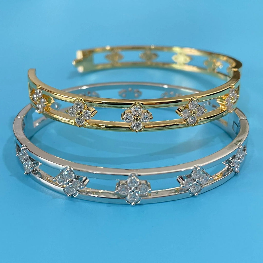 Gold and silver hollow women's bracelet with four-leaf clover design and zircon inlay.