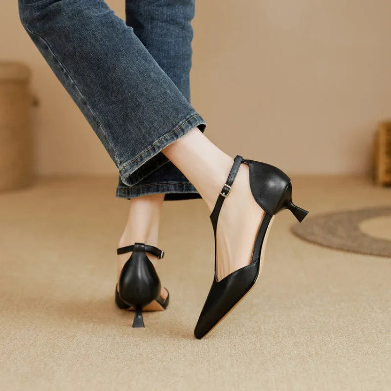 A pair of brown cowhide leather women's high heels with a pointed toe on a plain background.