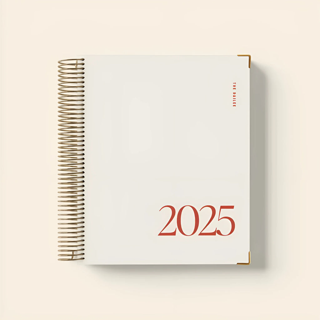 Cherry red spiral coil notebook open on a desk showing paper pages and binding.