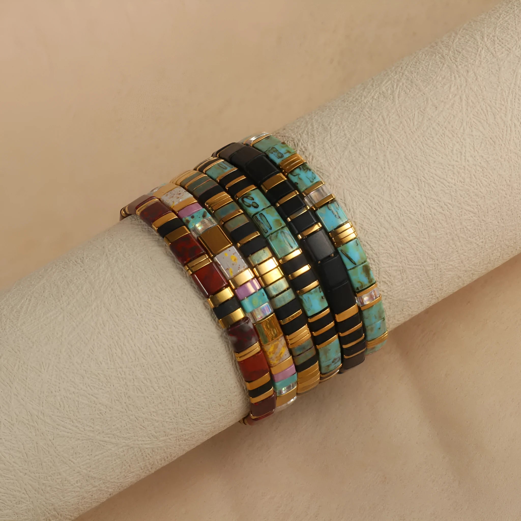 Geometric glass and coloured glaze beaded bracelet in milky white on a wrist.