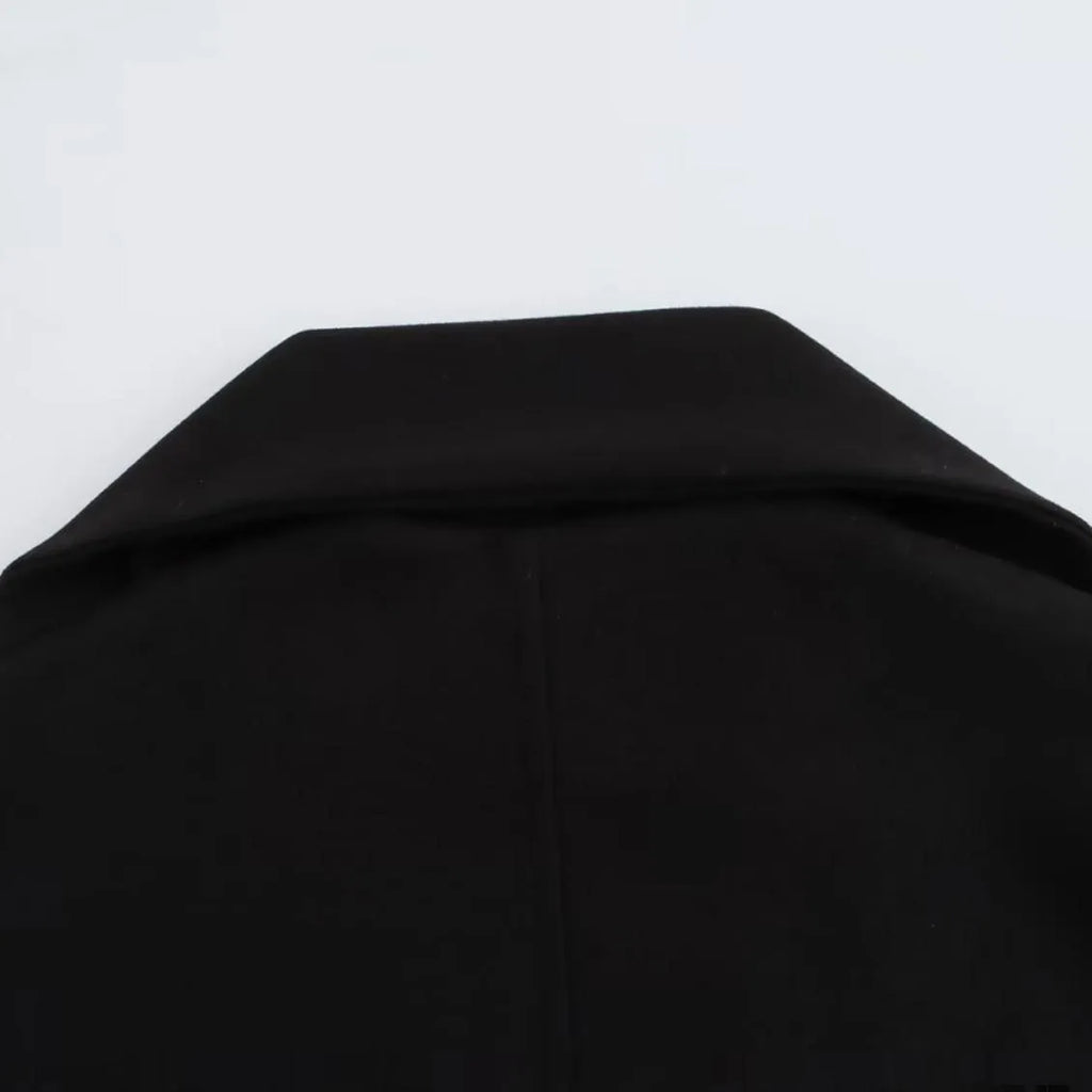 Women's long black polyester coat with a faux fur collar, shown in a street fashion style.